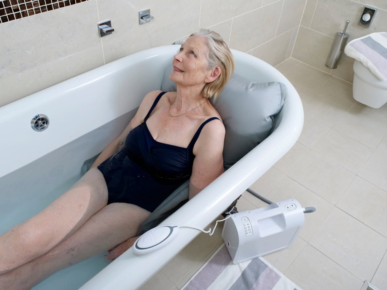 A white Pro Bath chair lift sitting inside a clean, modern bathtub, ready for use, illustrating accessible bathing in a residential home setting.